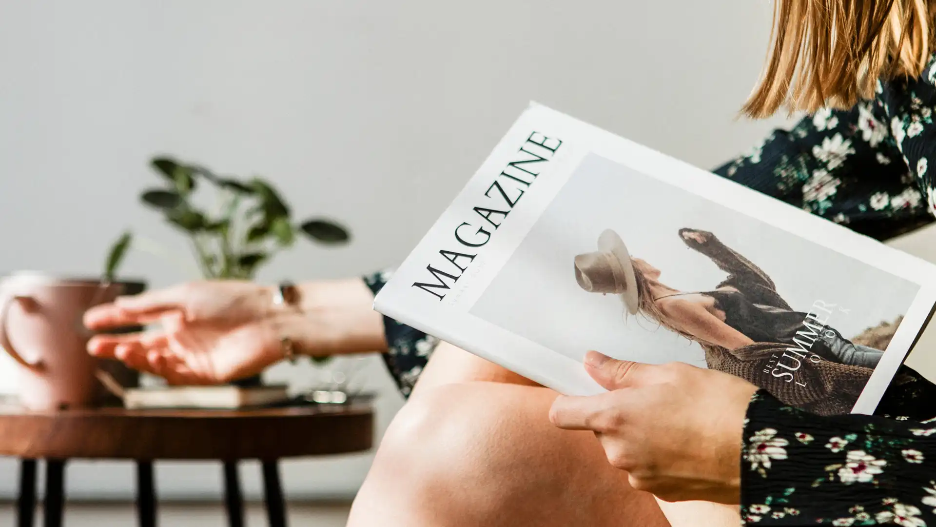 Relaxed meeting setting with a person holding a magazine, captured inside our Sunshine Coast design studio with soft natural light and a warm, casual atmosphere.